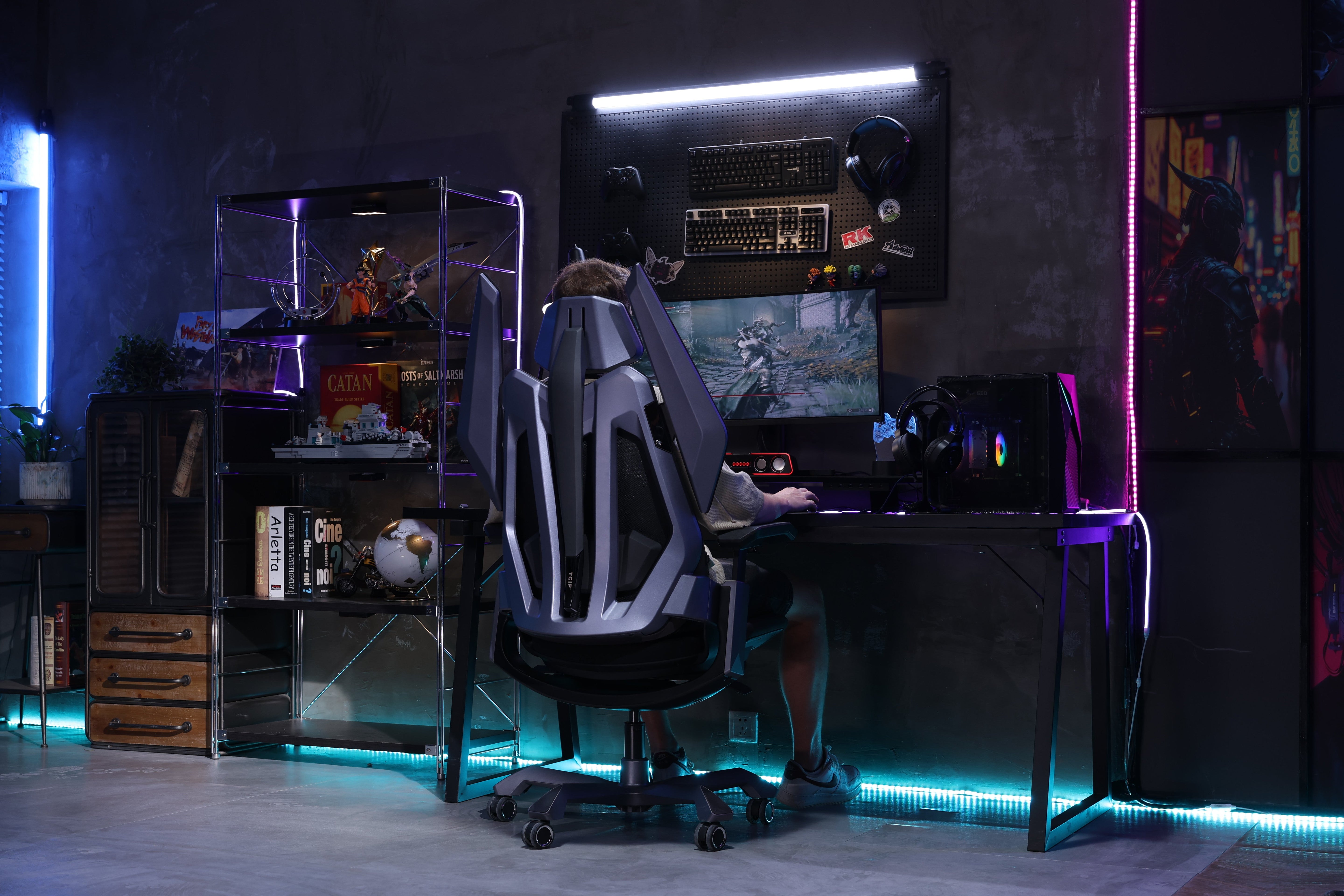 Picture showing the TGIF T0 from the back in front of a gaming setup with a person sitting on it and playing video games