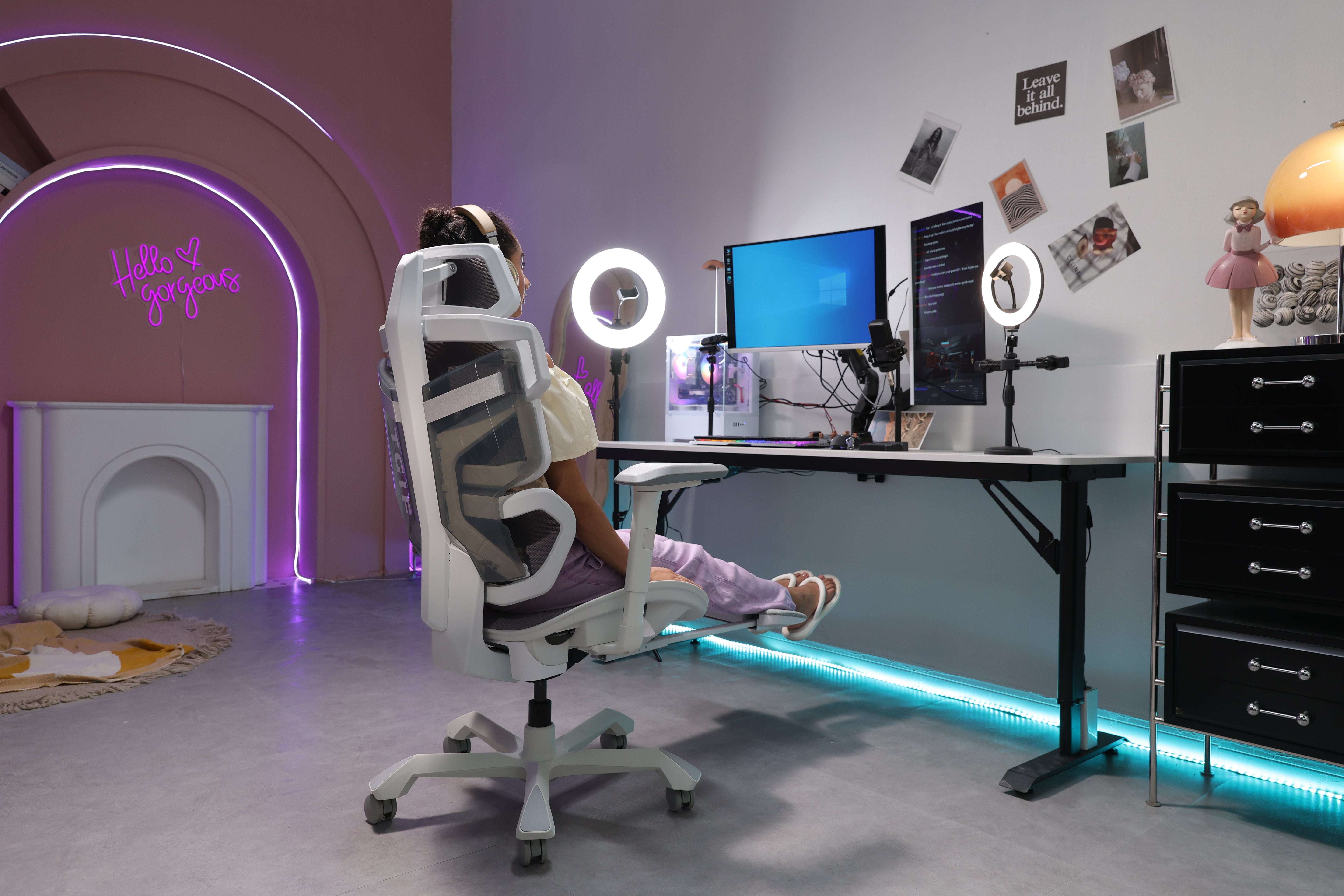 Picture showing a person sitting on a TGIF Ace Home white in front of a setup and watching her screen