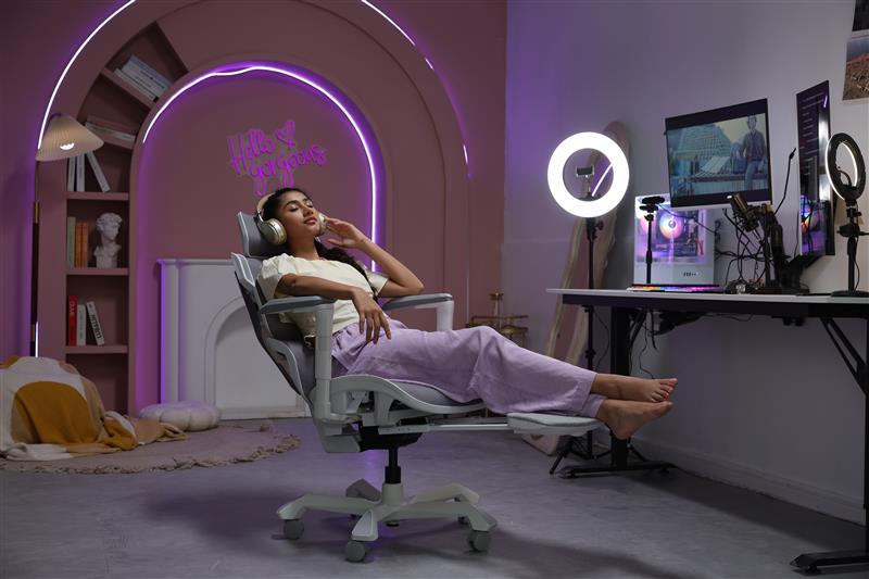 Picture shwing the TGIF ACE Home White with one person sitting on it and their legs stretched out thanks to the retractable support