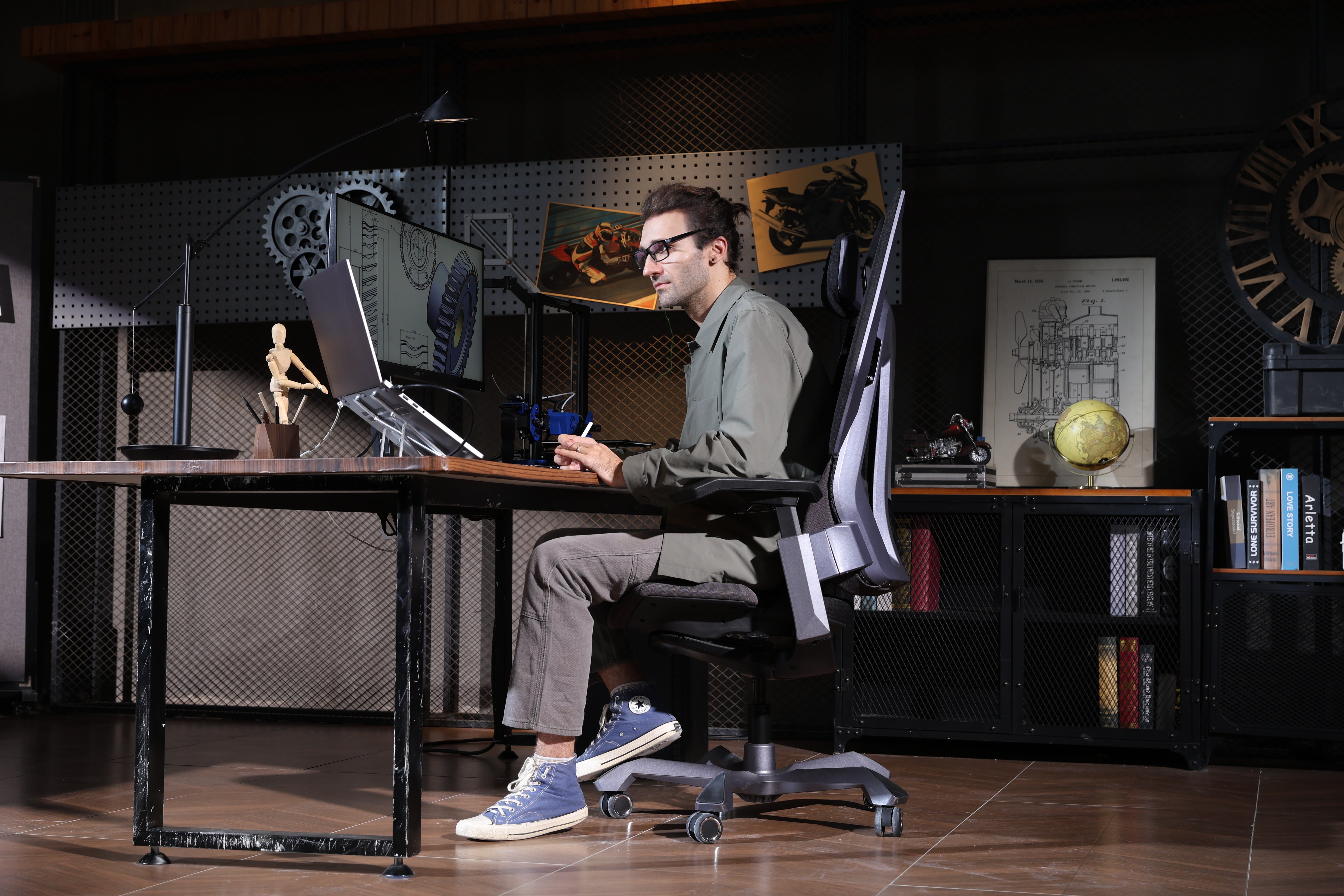 Picture showing a person working at his desk and sitting the TGIF T0 with his foot on the 58° inclined chair base.